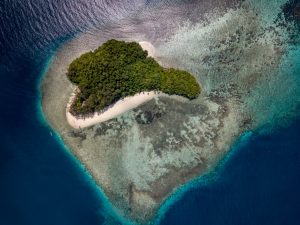 Aerial view of a heart-shaped, tropical island.