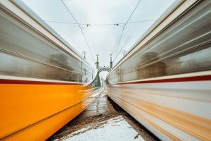 Urban photograph of two trams in front of the Liberty Bridge.