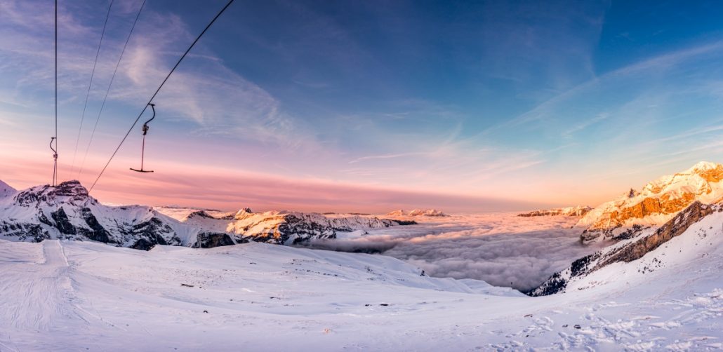 Landscape shot of swiss mountains in a sea of fog at sunset.