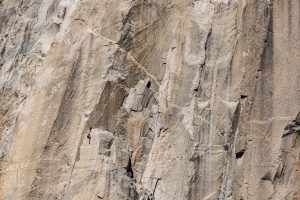 Landscape photograph of a rock face with climbers.