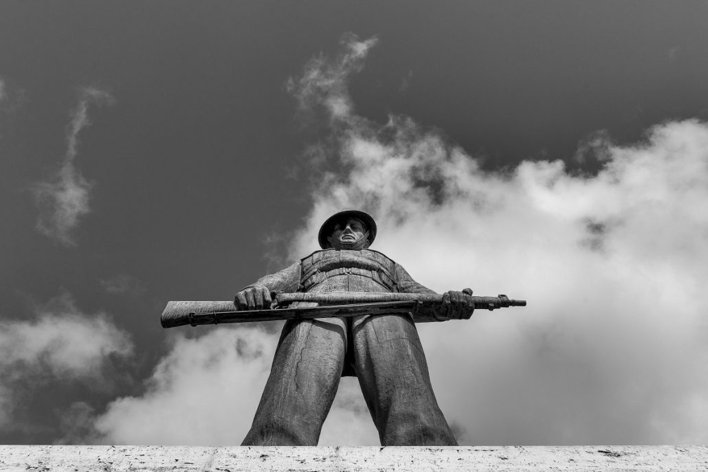 Urban photograph of a bronze statue from a war memorial.