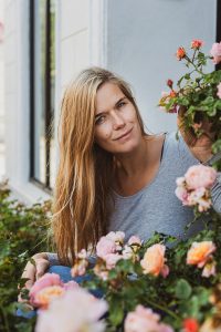 Portrait shot of a young woman behind roses.