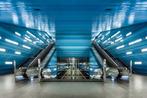 Night shot of a blue tiled subway station.