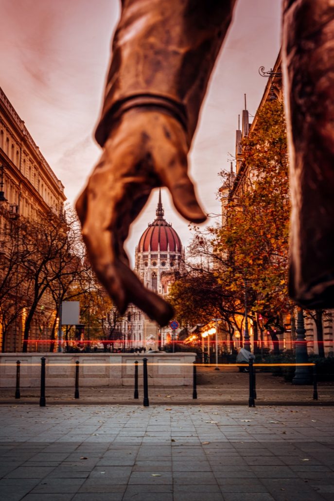 Architectural photograph of the Hungarian Parliament by the hands of Ronald Reagan statue.