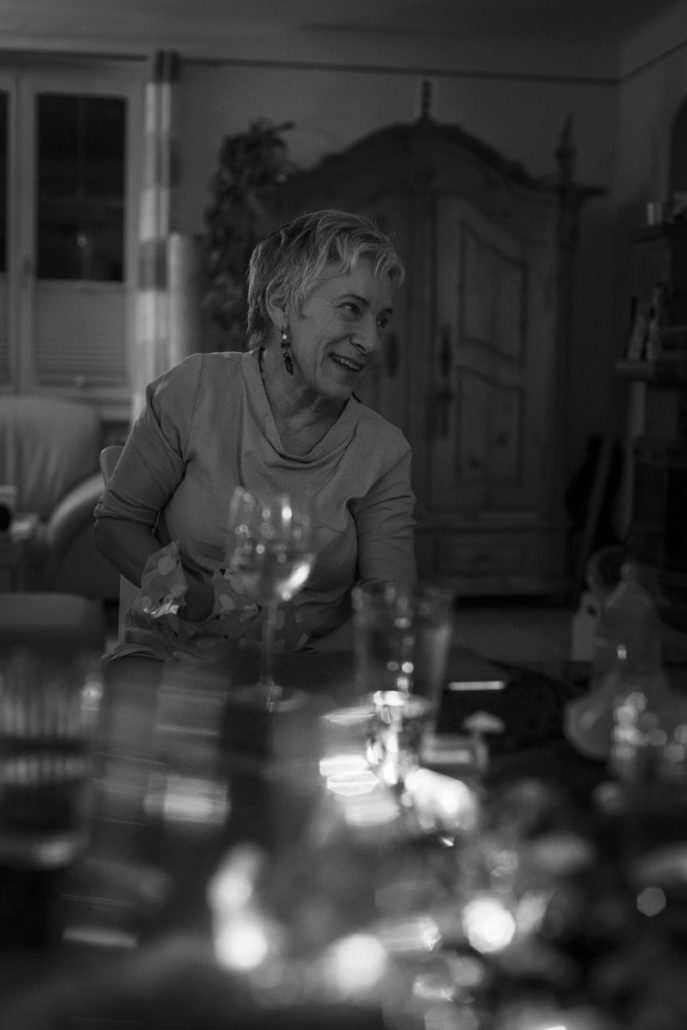 Black and white portrait of a woman at a set table.