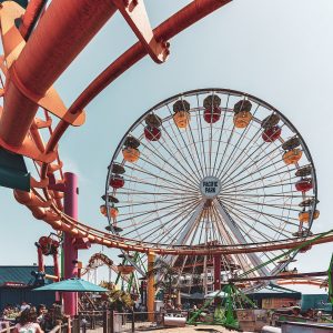 Urban shot of a roller coaster and ferry wheel.