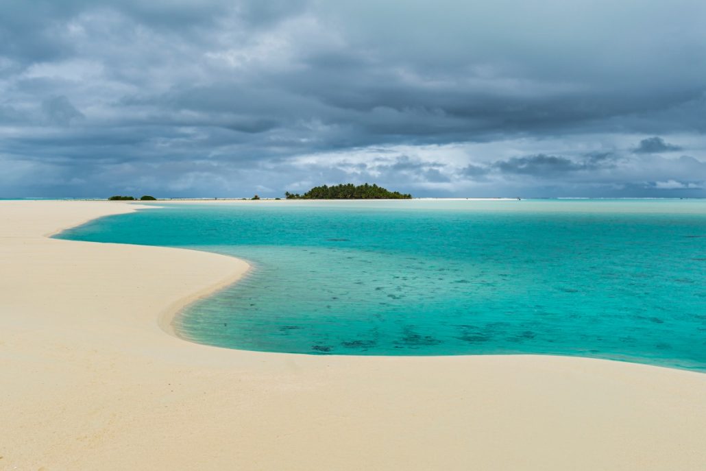 Landscape shot of a sandbank in front of a tropical island.