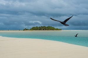 Landscape shot of a sandbank in front of a tropical island.
