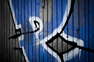 Urban shot of blue letters sprayed on a wall.