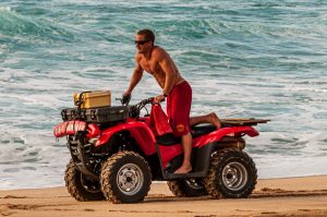 Portrait shot of a lifeguard on a quad bike.