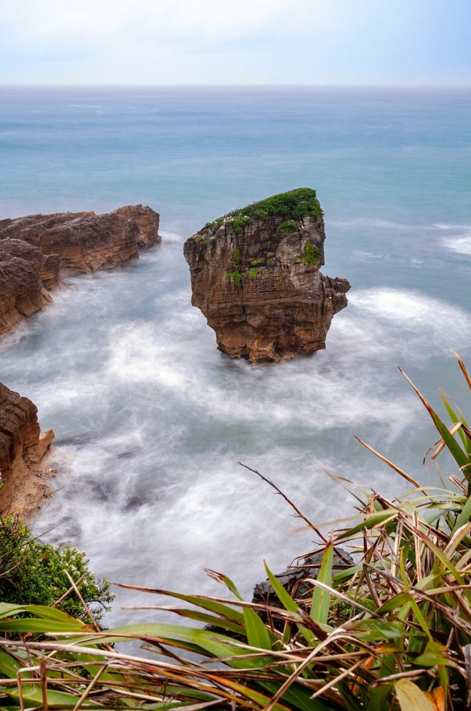 Landscape photograph of a single rock in the sea.